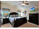 Comfortable main bedroom with ceiling fan and windows, featuring a dark wood bed frame and side tables at 3519 S 185Th Dr, Goodyear, AZ 85338