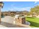 Outdoor kitchen features built-in grill, stone countertop, with a beautiful mountain view in the background at 3616 E Kachina Dr, Phoenix, AZ 85044