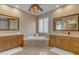 Luxurious bathroom featuring a soaking tub, dual vanities, and decorative lighting at 3616 E Kachina Dr, Phoenix, AZ 85044