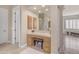 Neutral bathroom vanity area featuring framed mirrors, a sitting bench, and ample storage at 3616 E Kachina Dr, Phoenix, AZ 85044