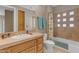 Well-lit bathroom featuring a tiled shower-tub combination and a granite countertop vanity sink at 3616 E Kachina Dr, Phoenix, AZ 85044