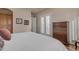 Bright bedroom with large bed, shuttered doors, and dark wooden dresser at 3616 E Kachina Dr, Phoenix, AZ 85044