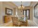 Elegant dining room with glass table, upholstered chairs, buffet, and ornate chandelier at 3616 E Kachina Dr, Phoenix, AZ 85044