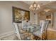 Formal dining room with glass table, upholstered chairs and ornate chandelier at 3616 E Kachina Dr, Phoenix, AZ 85044