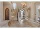 Bright foyer with stone floors, high ceilings, chandelier, decorative staircase, and iron doors at 3616 E Kachina Dr, Phoenix, AZ 85044