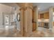 Elegant hallway featuring stone pillars, tile flooring, and a glimpse of the bar area at 3616 E Kachina Dr, Phoenix, AZ 85044