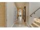 Hallway with travertine floors, arched doorway, and antique mirror adjacent to staircase at 3616 E Kachina Dr, Phoenix, AZ 85044