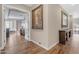 Inviting hallway with hardwood floors, artwork, and an archway leading to a spacious living area at 3616 E Kachina Dr, Phoenix, AZ 85044