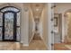 Long hallway with detailed tiled floors, opening to front door with dark metal frame at 3616 E Kachina Dr, Phoenix, AZ 85044