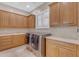 Well-equipped laundry room with ample cabinetry, counter space, sink, and modern appliances at 3616 E Kachina Dr, Phoenix, AZ 85044