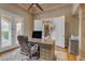 Well-lit home office featuring a wooden desk, ceiling fan, and elegant view of the home's entry at 3616 E Kachina Dr, Phoenix, AZ 85044