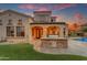 Outdoor kitchen area featuring a stone countertop, built-in grill and view of the pool and lush backyard at 3616 E Kachina Dr, Phoenix, AZ 85044