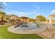 Resort-style pool with a rock waterfall, lush landscaping, and a covered lounge area, creating a relaxing oasis at 3616 E Kachina Dr, Phoenix, AZ 85044