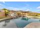 Serene pool area with a waterfall feature, lush landscaping, and comfortable seating, offering a private retreat at 3616 E Kachina Dr, Phoenix, AZ 85044