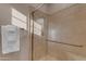 Shower stall with glass door, tiled walls, and chrome hardware with a towel rack to the side at 3616 E Kachina Dr, Phoenix, AZ 85044