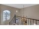 Elegant staircase with iron railings and a chandelier, showcasing views of the lush outdoor landscape at 3616 E Kachina Dr, Phoenix, AZ 85044