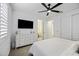 This bedroom features neutral tones, closet and bathroom access, and a ceiling fan at 40481 W Desert Fairways Dr, Maricopa, AZ 85138