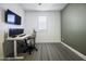 Stylish office space featuring modern desk setup with monitors, an ergonomic chair, and a neutral-toned carpet at 40481 W Desert Fairways Dr, Maricopa, AZ 85138