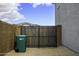 Side yard featuring wood fence, a garbage can and gravel at 40481 W Desert Fairways Dr, Maricopa, AZ 85138