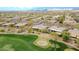 Scenic aerial view of a golf course community with lush green fairways, sand traps, and mountain views at 42105 N Golf Crest Rd, Anthem, AZ 85086