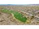 Expansive aerial view of a golf course highlighting the manicured green and sand traps within the desert community at 42105 N Golf Crest Rd, Anthem, AZ 85086