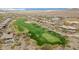 Aerial view of a desert community with lush green golf course featuring sand traps and views of mountains at 42105 N Golf Crest Rd, Anthem, AZ 85086