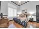 Inviting bedroom featuring hardwood floors, large window with shutters, neutral walls, and comfortable furnishings at 42105 N Golf Crest Rd, Anthem, AZ 85086