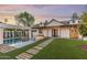 Inviting backyard at dusk showcasing pool with swim up bar, turf, fire feature, and cozy string lights at 542 E Hayward Ave, Phoenix, AZ 85020