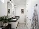 Well-lit bathroom with double sinks, framed mirrors, patterned floor tiles and decorative plants and towels at 542 E Hayward Ave, Phoenix, AZ 85020