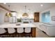 Modern kitchen with white cabinets, marble countertops, and a large center island with seating at 542 E Hayward Ave, Phoenix, AZ 85020