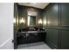 Luxurious powder room featuring a black marble countertop and custom mirror at 542 E Hayward Ave, Phoenix, AZ 85020