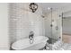 Stylish bathroom boasts subway tile, modern lighting, soaking tub, walk-in shower with black fixtures, and patterned floor at 6719 N 10Th Pl, Phoenix, AZ 85014