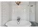 Bright bathroom features subway tile walls, modern fixtures, and soaking tub with a separate glass shower at 6719 N 10Th Pl, Phoenix, AZ 85014