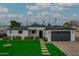 Well-manicured front yard with a modern exterior, a paved driveway, and a two-car garage at 6719 N 10Th Pl, Phoenix, AZ 85014