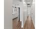 Hallway leading to a modern kitchen with white cabinets, stainless steel appliances, and wood-look flooring at 6719 N 10Th Pl, Phoenix, AZ 85014