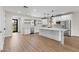 Modern kitchen featuring white cabinets, a large island, stainless steel appliances, and stylish floating shelves at 6719 N 10Th Pl, Phoenix, AZ 85014