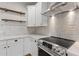 Contemporary kitchen features stainless steel oven and range hood, marble countertops, and stylish shelving at 6719 N 10Th Pl, Phoenix, AZ 85014