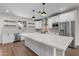 Bright kitchen with a large island, white cabinetry, stainless steel appliances, and modern pendant lights at 6719 N 10Th Pl, Phoenix, AZ 85014