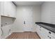 Modern laundry room featuring white cabinets, a countertop, and a door to the rest of the house at 6719 N 10Th Pl, Phoenix, AZ 85014