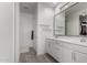 Bright bathroom featuring a double vanity with white cabinets, large mirror, and tile flooring at 7410 S 22Nd Ln, Phoenix, AZ 85041