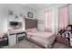 Bedroom showcasing bed with tufted headboard, vanity, and pink decor at 7410 S 22Nd Ln, Phoenix, AZ 85041