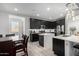 Contemporary kitchen featuring dark cabinetry, a center island, and a dining table at 7410 S 22Nd Ln, Phoenix, AZ 85041