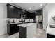 Modern kitchen with sleek black cabinets, stainless steel appliances, and an island at 7410 S 22Nd Ln, Phoenix, AZ 85041