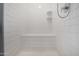 Tiled shower includes built-in seating and shampoo shelves at 7410 S 22Nd Ln, Phoenix, AZ 85041