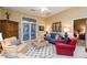 Comfortable living room features a ceiling fan, an area rug, a blue couch, and an entrance to a bedroom at 8270 E Corrine Dr, Scottsdale, AZ 85260