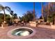 Inviting outdoor space features a circular spa, fire pit, and seating area surrounded by lush landscaping at 8270 E Corrine Dr, Scottsdale, AZ 85260