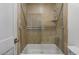 Shower-tub combo featuring glass doors and tile surround at 8653 E Royal Palm Rd # 1006, Scottsdale, AZ 85258