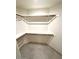 Walk-in closet with built-in shelving and neutral tile flooring at 8653 E Royal Palm Rd # 1006, Scottsdale, AZ 85258