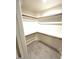 Walk-in closet with built-in shelving and neutral tile flooring at 8653 E Royal Palm Rd # 1006, Scottsdale, AZ 85258