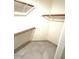 Walk-in closet with built-in shelving and neutral tile flooring at 8653 E Royal Palm Rd # 1006, Scottsdale, AZ 85258